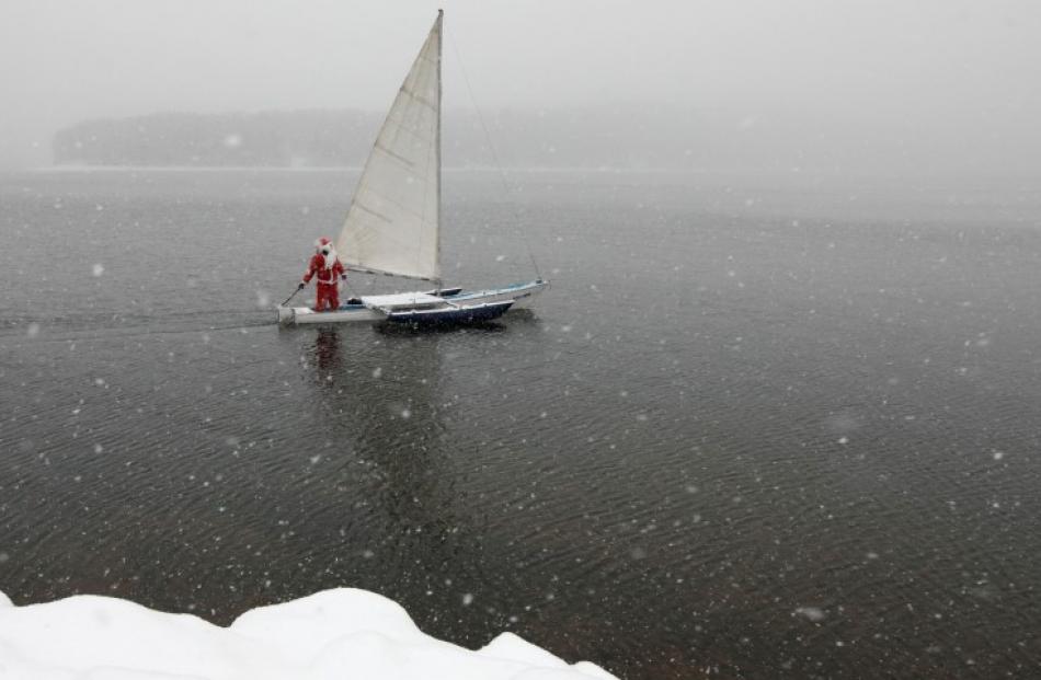 A member of the 'Skipper' yacht club sails his trimaran to mark the ending of the sailboat season...