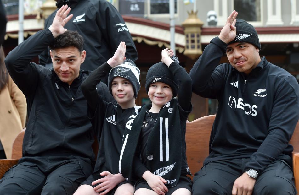 Kano (left), 9, and Beau, 6, get their fins up with All Blacks Shaun Stevenson and Anton Lienert...