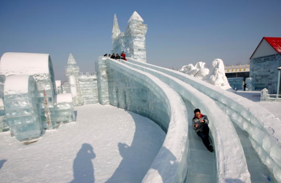A man rides a slide on an ice sculpture. REUTERS/Kim Kyung-Hoon