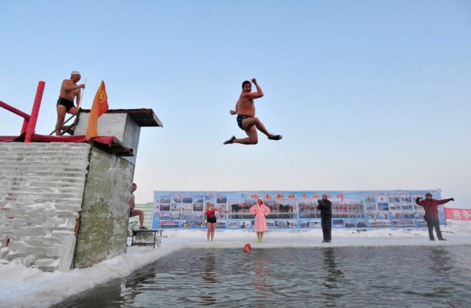 A swimmer jumps into the icy water of partially frozen Songhua River. REUTERS/Sheng Li