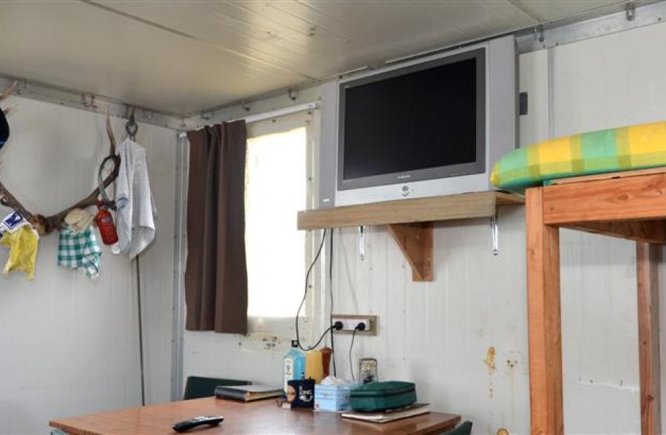 A flat-screen TV adorns the wall of the  hut.