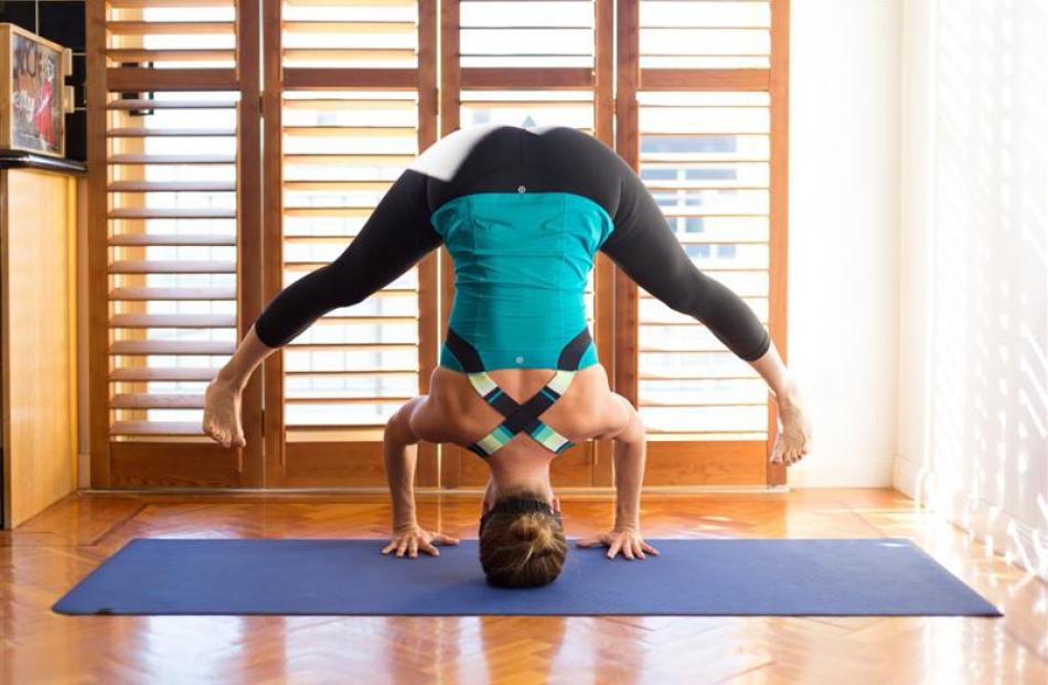 Yoga moves in a Lululemon Push Your Limits tank and Wunder Under Crop pants.