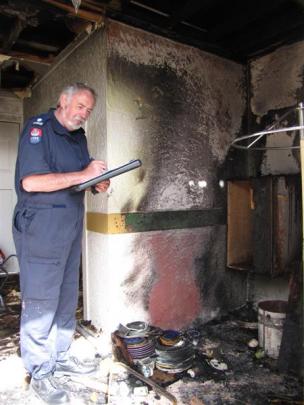 Fire investigator Mike Cahill, of Invercargill, checks the alcove where a  fire  started at...