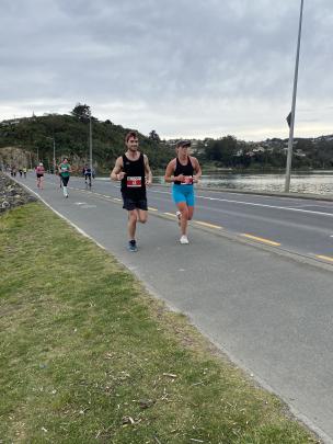 Full-marathon competitors Kaleb Hill (43) and Meg Creah (154) look strong running across the...