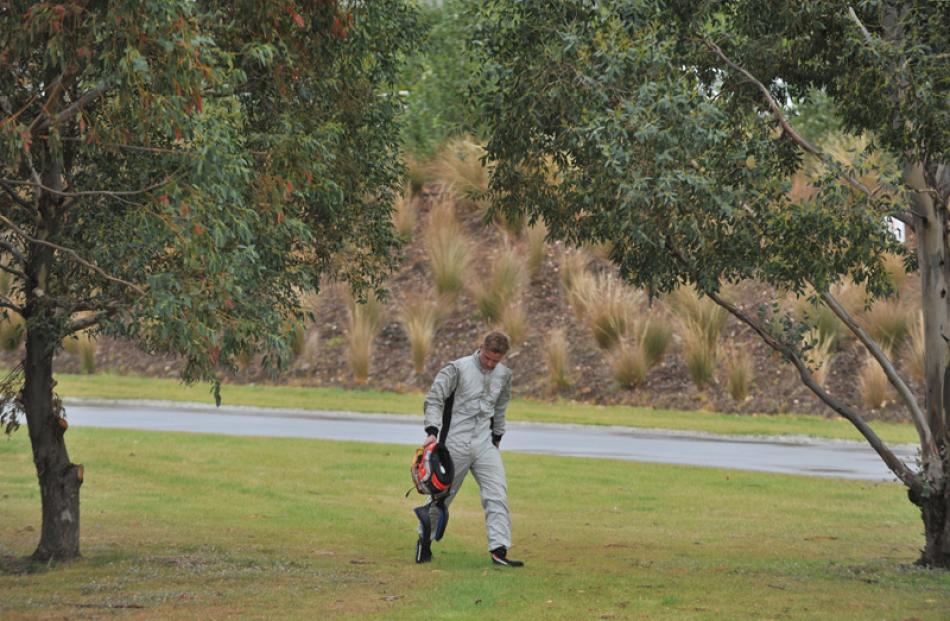 A driver walks back to the pits after spinning his car off the track.