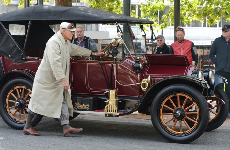 Neil Rooney pushes his 1914 Buick down the Octagon carriageway.