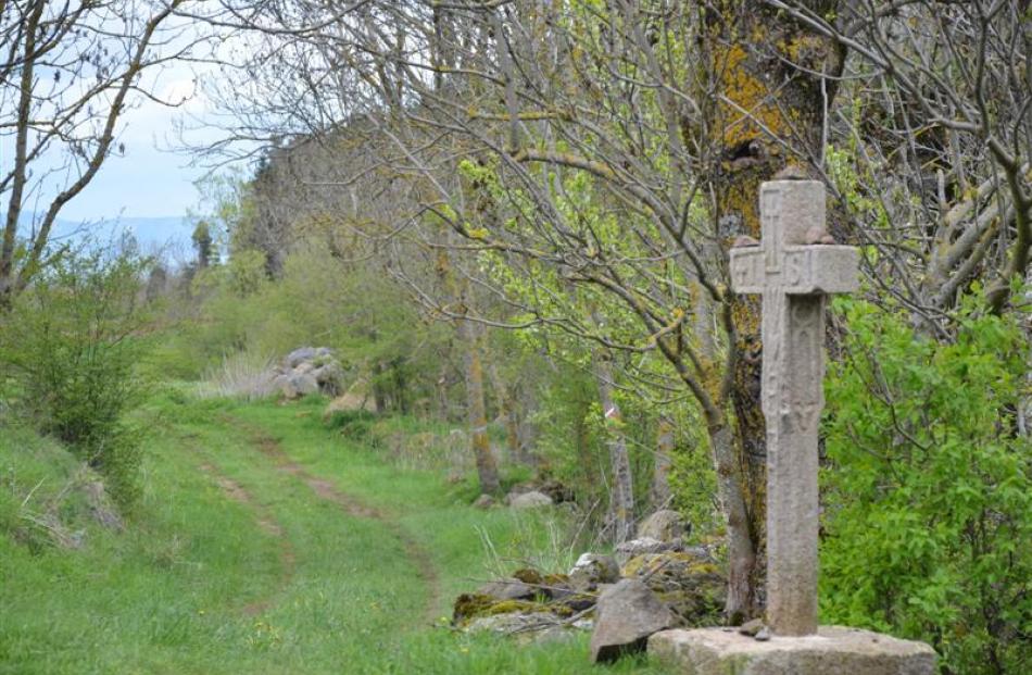 A cross marks the Chemin de St-Jacques pilgrim trail near Le Puy-en-Velay, in France, where Clyde...