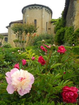 Flowers surround a historic building along the Chemin de St-Jacques pilgrim trail through France.