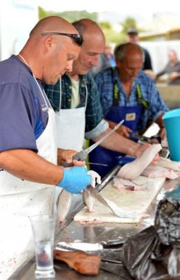 Filleting the catch for the charity auction are (from left) Jim Varga, of Allanton, David Denny,...