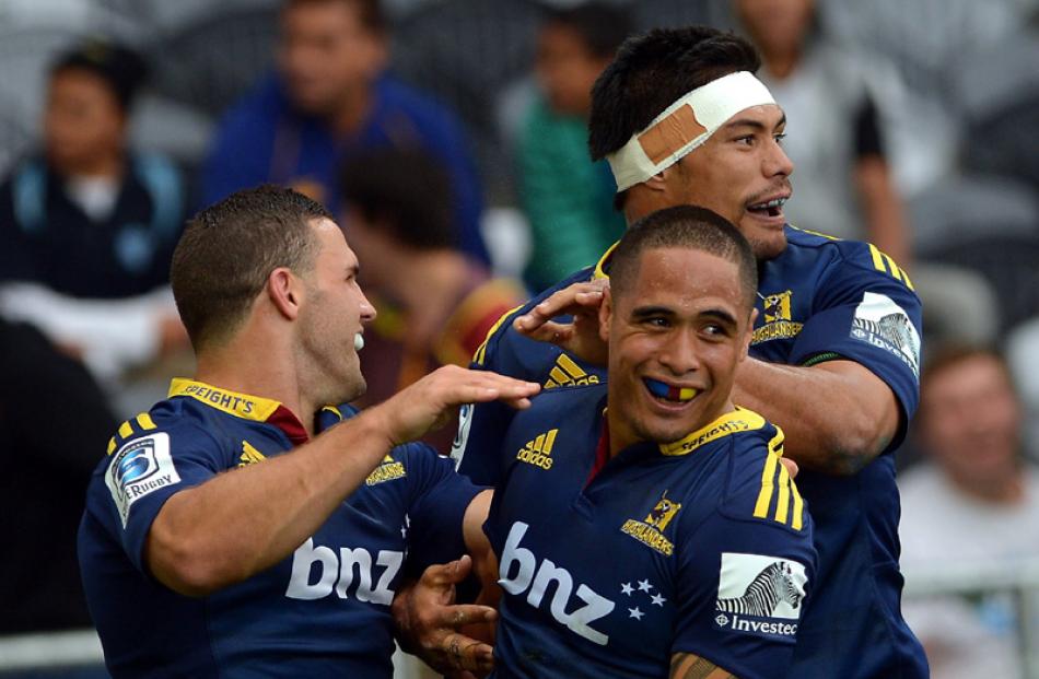Highlanders (from left) Shaun Treeby, Aaron Smith and Shane Christie celebrate Smith's try.