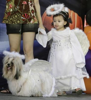 A girl and her dog are seen during a Halloween dog show for the benefit of an animal welfare...