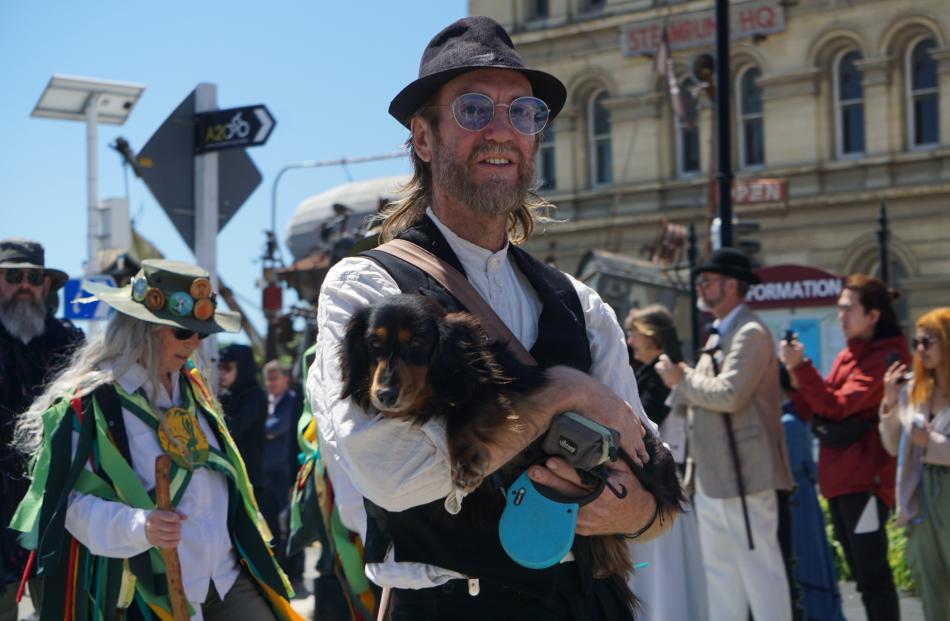 Figo the miniature long-haired Dachshund is carried during the parade by Mark Allan, of Oamaru.