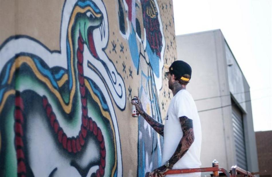 Street artist Steen Jones, of Melbourne, works on an Authority Clothing mural on Beith St, in...