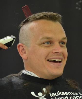 Constable Matt Davidson, of Dunedin police, has his hair shaved at Farmers  in Dunedin on...