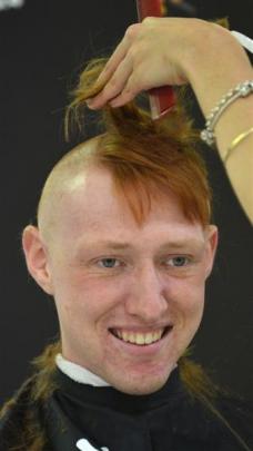 Daniel Rumbal, of St John Dunedin, has a comb run through his hair mid-shave at Farmers  on...