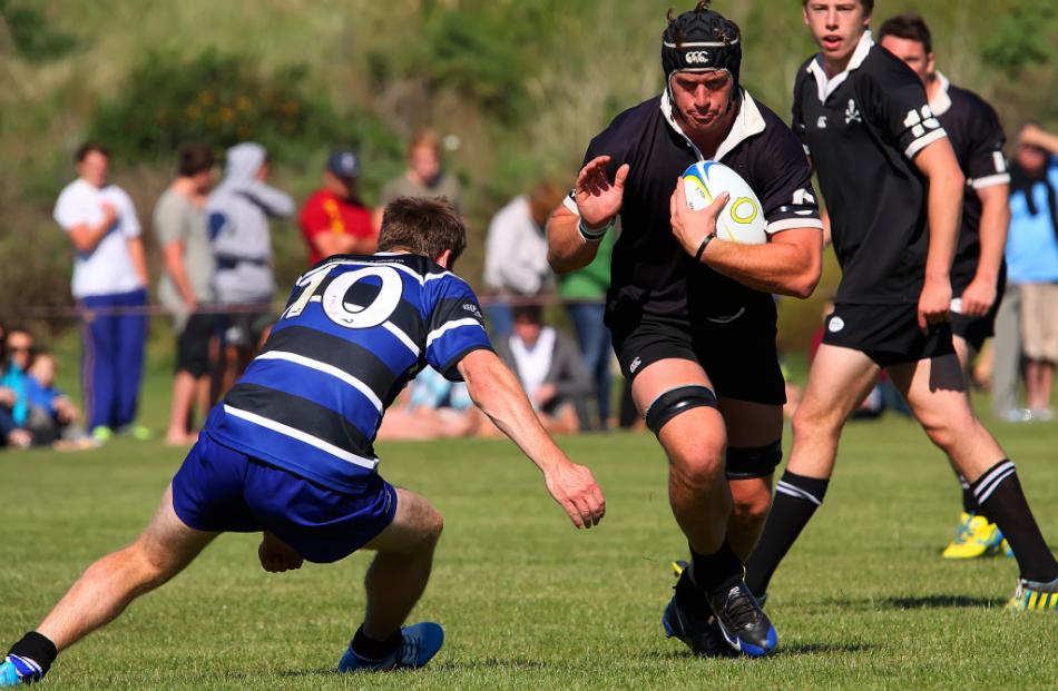 Pirates blindside flanker Ben Sexton prepares to be tackled by Kaikorai No 10, Cameron Rutherford...