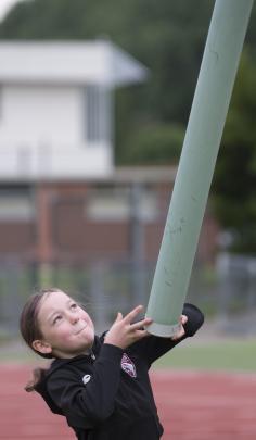 Grace Martin (9) gives the caber a heave.