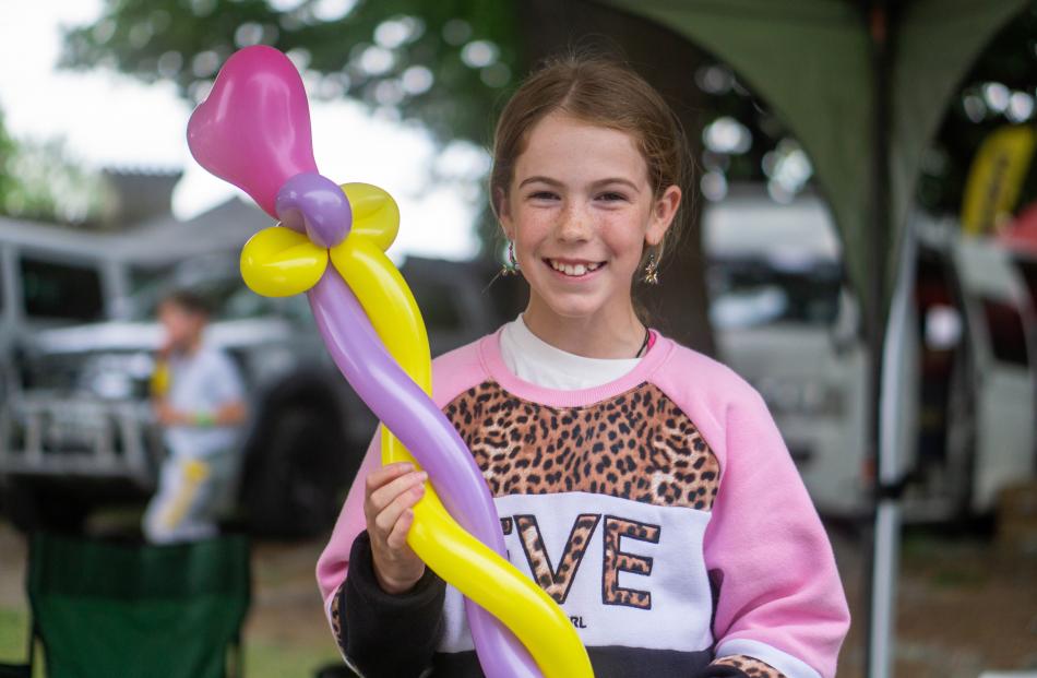 Gemma Thornley, 10, of Timaru, shows off a freshly made balloon flower from her stall.