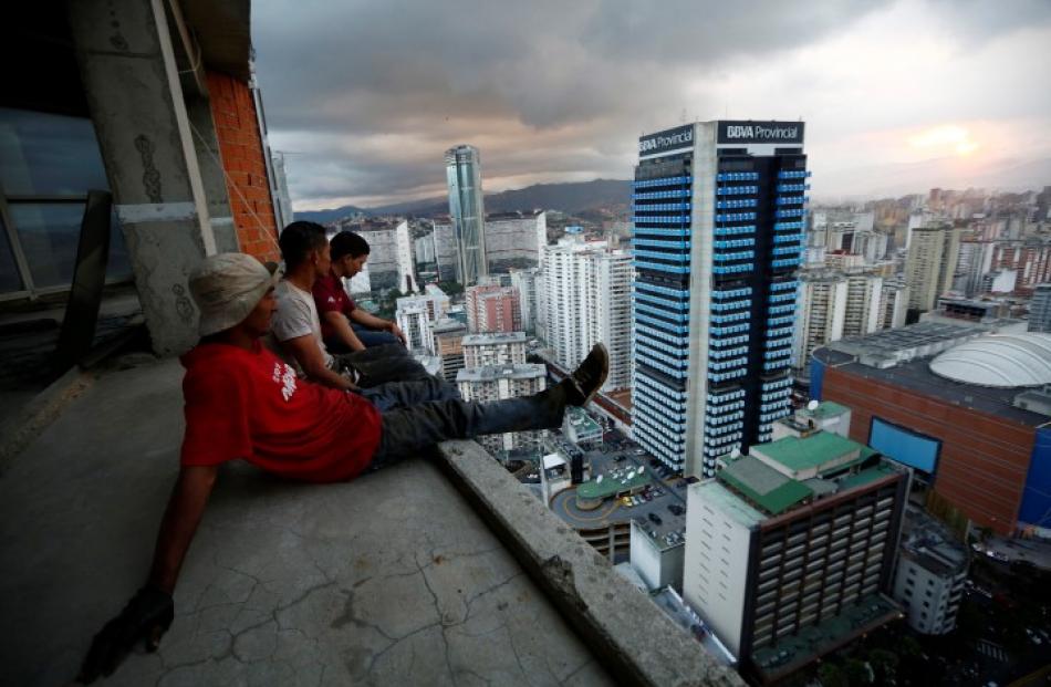 Men rest after salvaging metal on the 30th floor. REUTERS/Jorge Silva