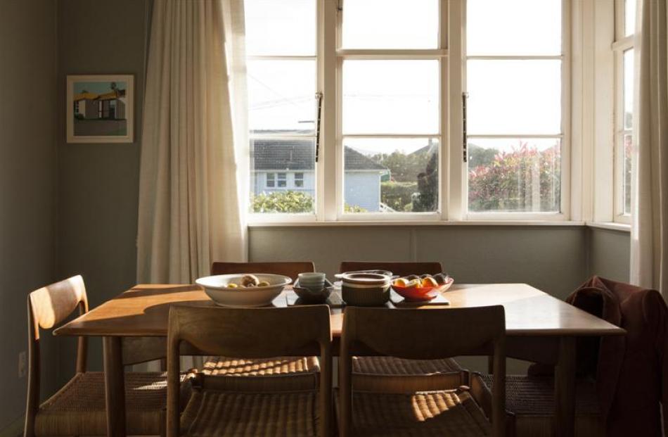 Morning light from the corner window warms the dining room. The screen print is Spacious,  by...
