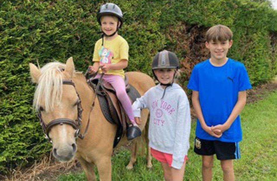 Everyone loves a pony ... Stella Hawker, 6, sits on Pearl as siblings Lucia, 9, and Kellan, 11,...