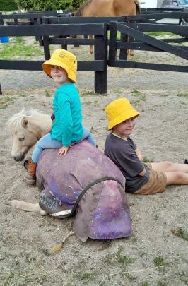 Downtime ... Isabella, 4, and Jackson, 9, Marsh relax with Isabella's pony Rocket in his yard...