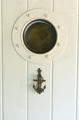A porthole and weather vane add to the nautical feel.