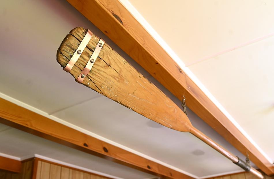 An oar is suspended from the living room ceiling.
