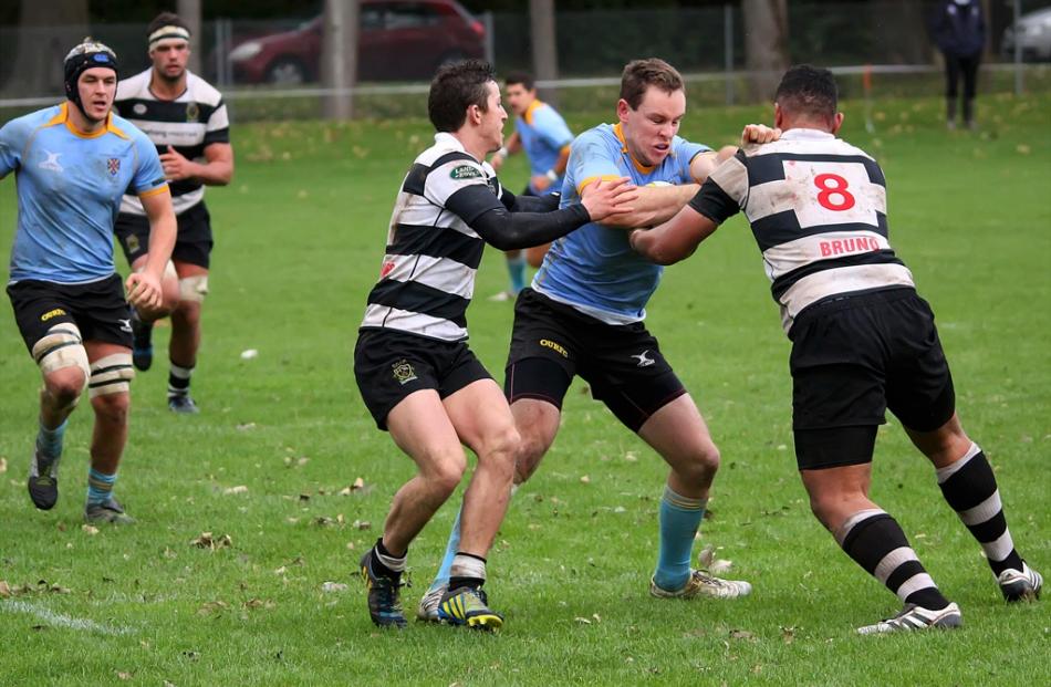 Sam McLachlan for University A drives into Southern defenders Lafaele Faamoe and Josh Walden...