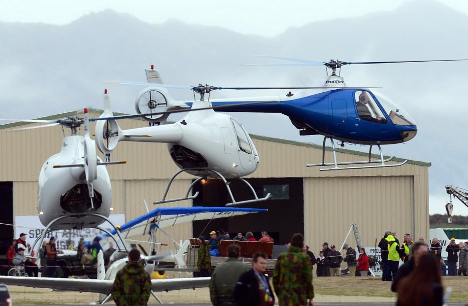 Helicopters hover above the apron waiting for their  display.