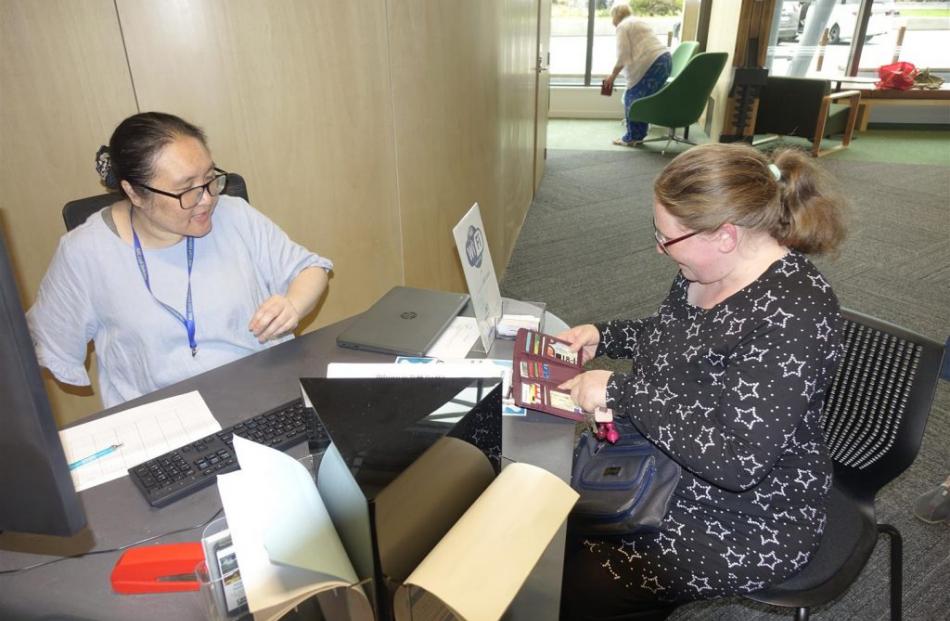 Technical librarian Phoebe Wang helps Ashburton resident Nikau-Robin Schimanski-Cootes update her...