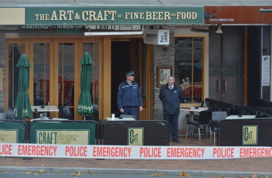 A police officer and a security officer stand outside a cordoned-off Craft Bar in the Octagon...