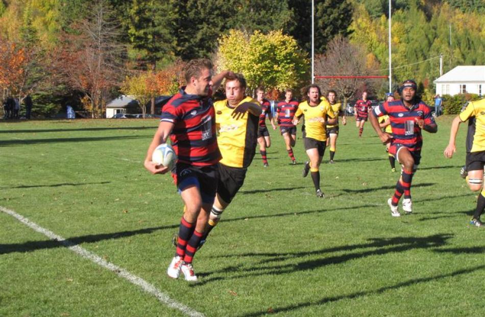 Arrowtown's Gareth Jones swats away an Upper Clutha A player at Jack Reid Park on Saturday.