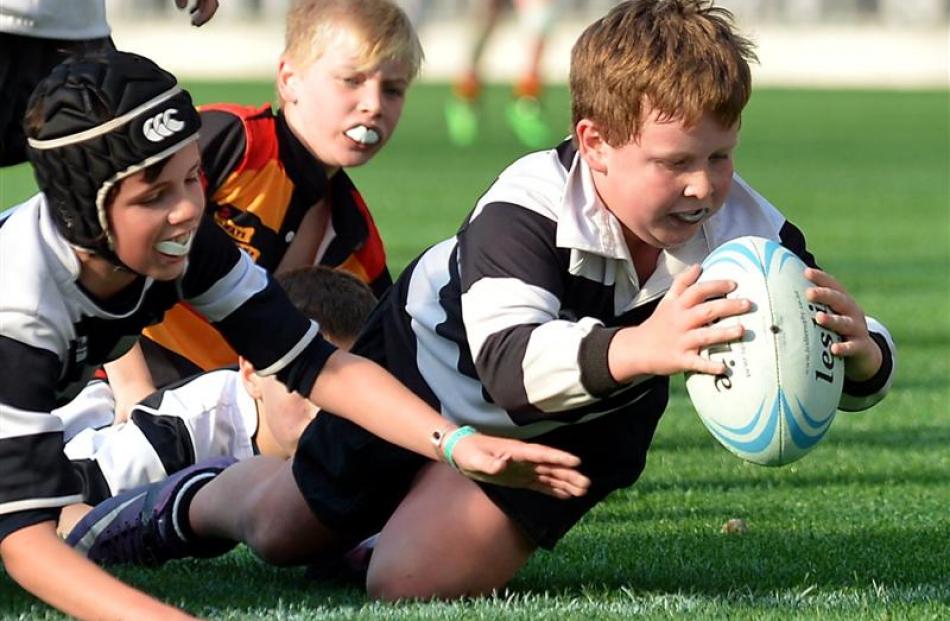 Lachlan Cowan (10) of the Southern Magpies under-11 team scores a try against the Zingari...