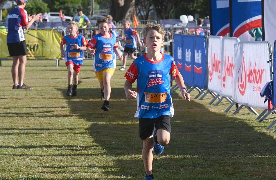 Xavier McMinn, 9, of Timaru, leads a group of runners towards the finish line at the Sanitarium...
