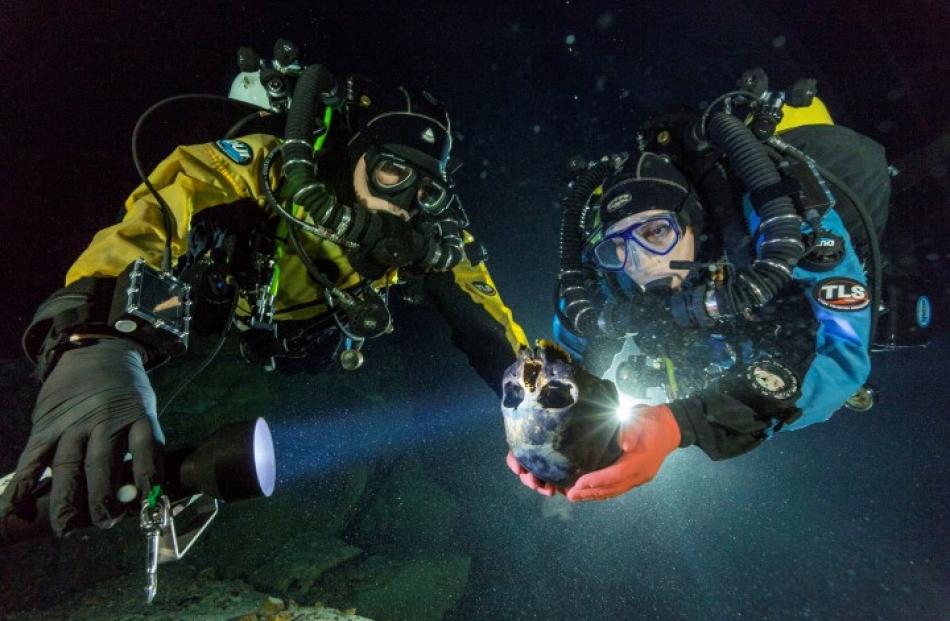 Susan Bird and Alberto Nava transport the skull of the skeleton to an underwater turntable so...