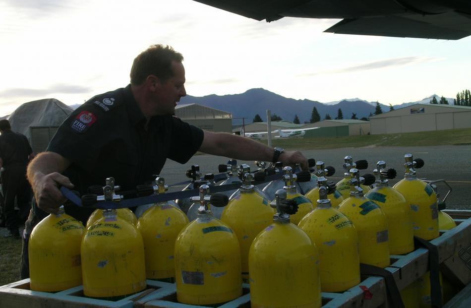 Volunteer fire officer Bruno Galloway secures dive tanks at Wanaka Airport.
