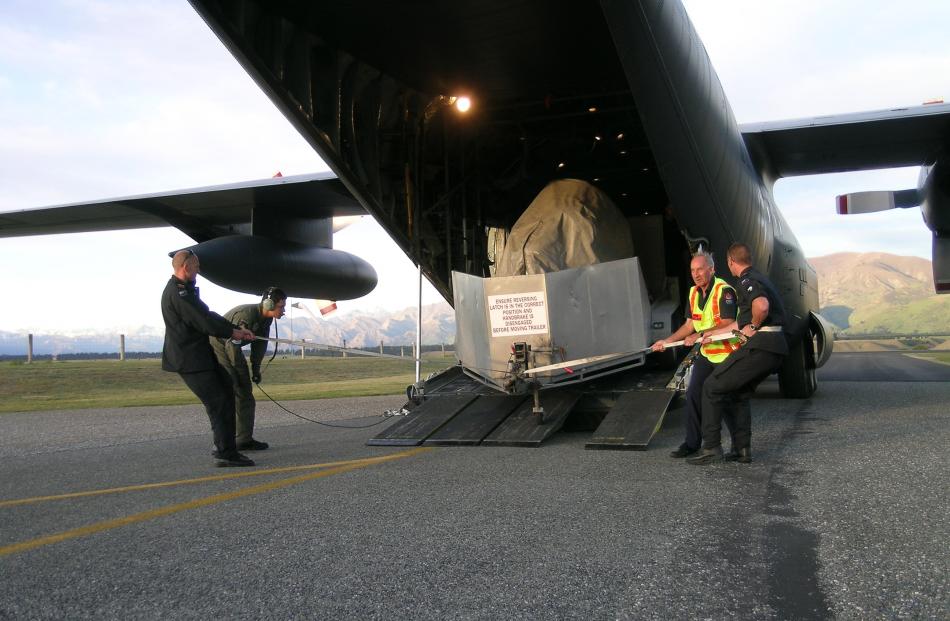 Wanaka Airport operations manager Ralph Fegan (facing camera) assists three Navy officers unload...