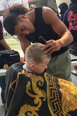 Hunter McPherson (5) gets a free haircut from trainee hairdresser Te-ava Nicholas. Hunter looked...