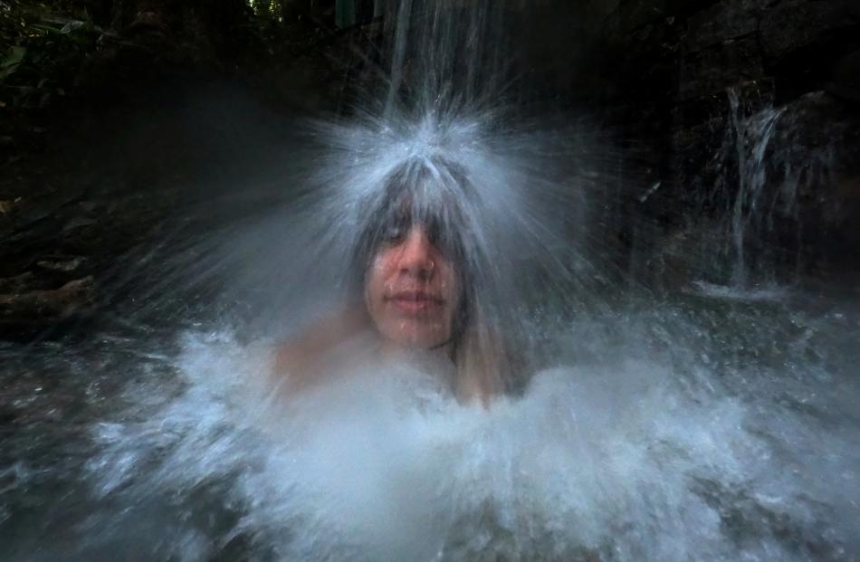 Giovanna Barbosa, 19, enjoys cold water in the Tijuca forest, marking World Water Day in Rio de...