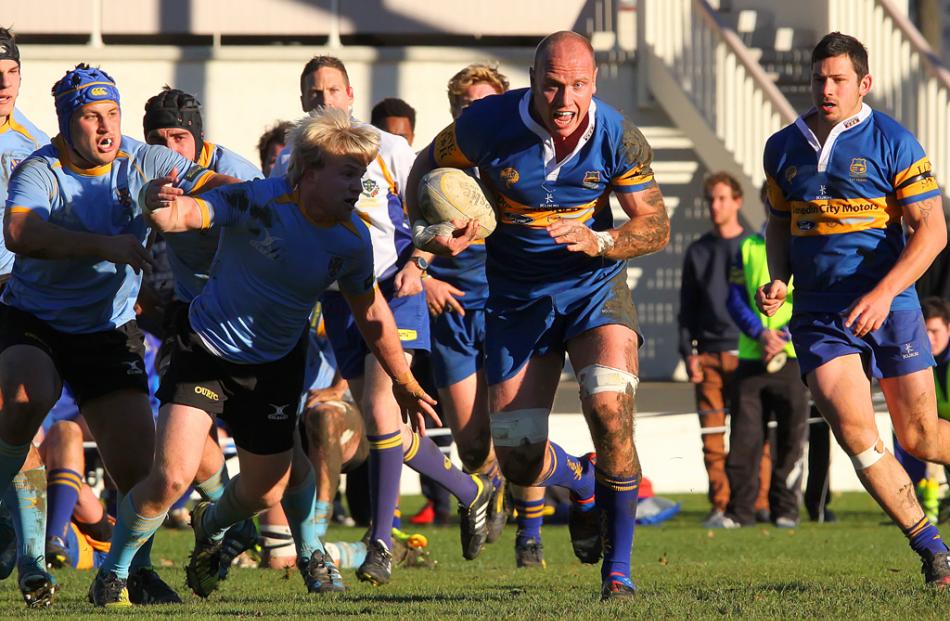 Taieri No 8 and Captain Charlie O'Connell makes a strong driving run past University A halfback...