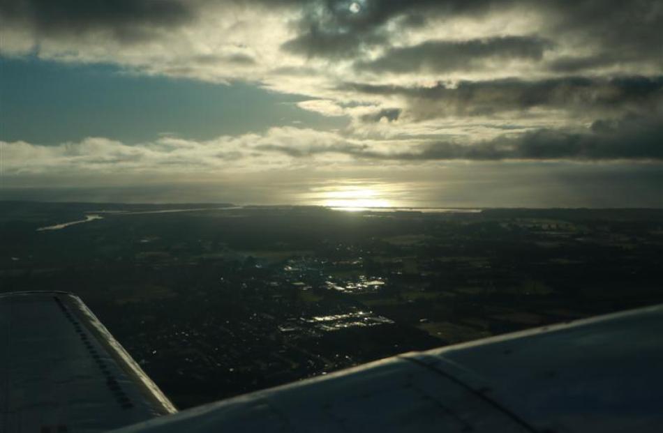 The sun rises in Christchurch as the Mainland Air plane starts  descending.