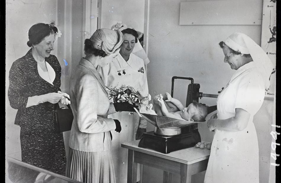 Queen Elizabeth visits the hospital in 1954 and watches a sister weigh a baby. PHOTO: EVENING STAR