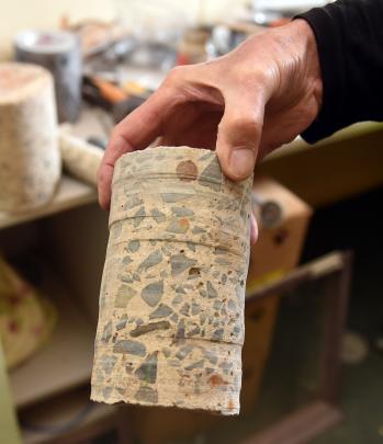 Kevin Rogers holds concrete removed from the building when holes were cut for services. The...