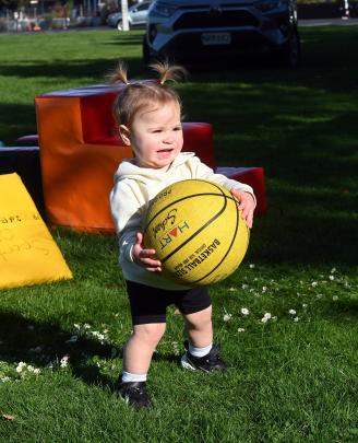 Theodora Paulino, 15 months, of Dunedin, grabs hold of a basketball.
