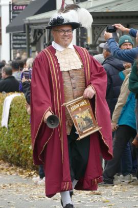 Town crier Dougal MacPherson leads the Arrowtown Autumn Festival Street Parade down Buckingham St...