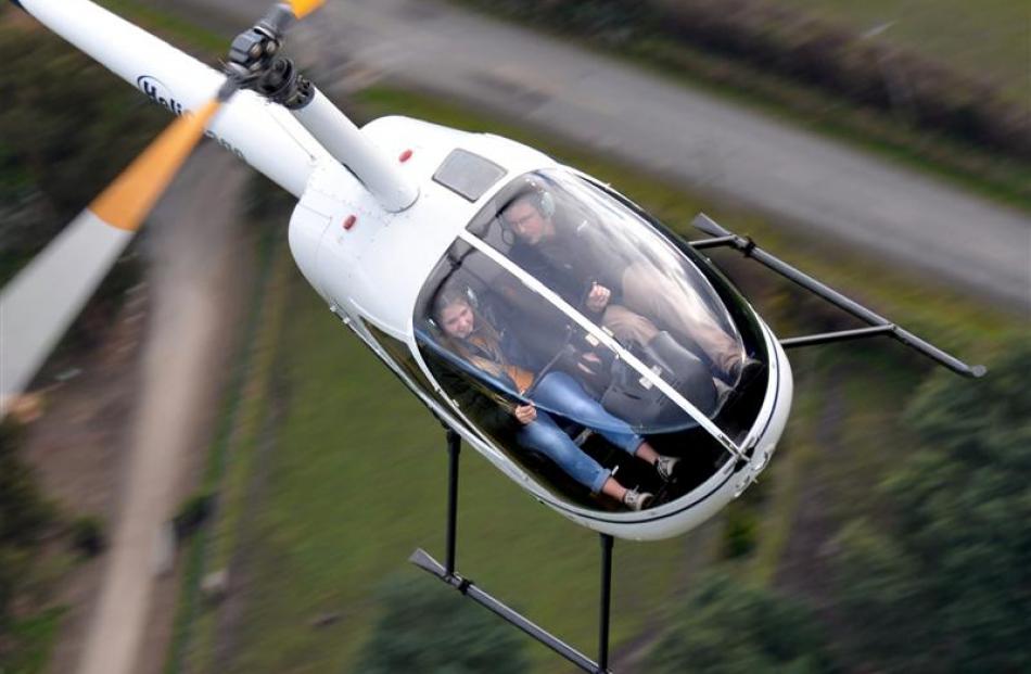 Helicopter pilot Aaron Whitley helps birthday girl Jade MacMillan (15), who was born in a...