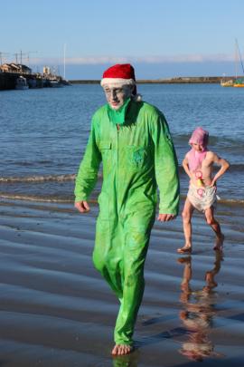 Mid-winter swim veteran Donald Smyth comes ashore.