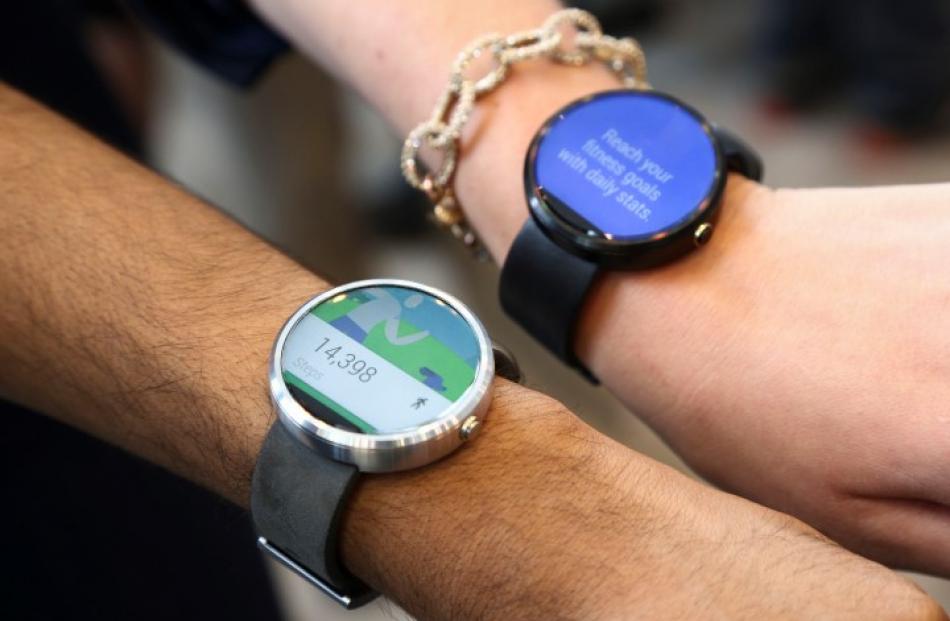 Google employees show off two versions of the Moto smartwatch. REUTERS/Elijah Nouvelage