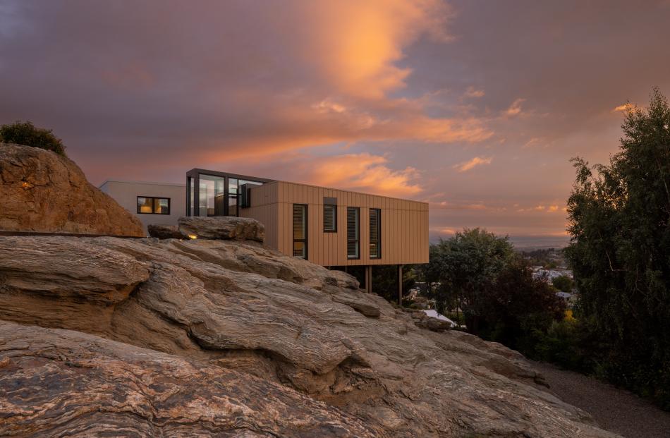Simple "boxes" on steel poles float above the rock on this Alexandra site. The house was designed...